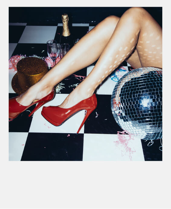 Legs with red heels on the floor afterparty